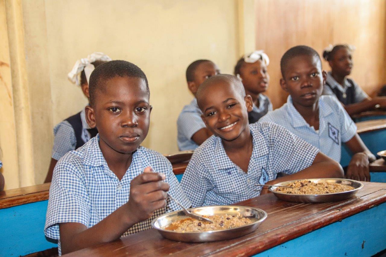 Deti na Haiti jedia školské jedlo v triede