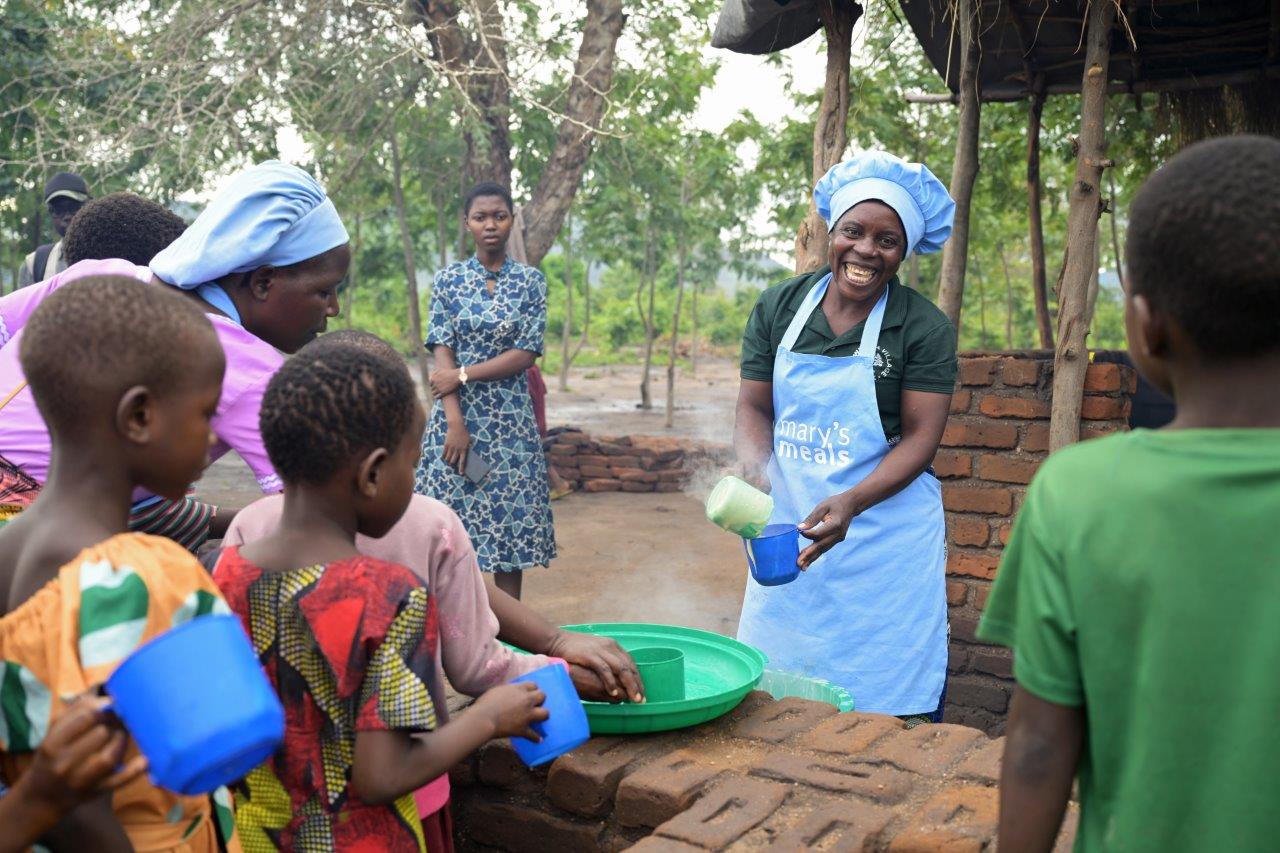 Dobrovoľníčka Mary’s Meals s deťmi pri školskom jedle