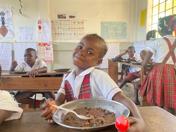 Dieťa zapojené do programu školského stravovania na Haiti